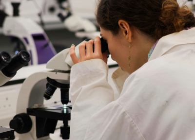 Woman looking into a microscope